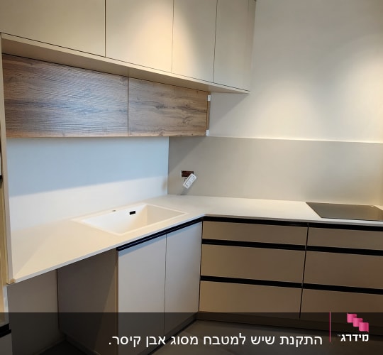 מטבח עם משטחי שיש בהירים וארונות מודרניים